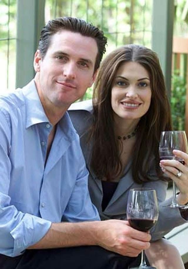 And young and gelled Gavin Newsom and his shitty center-parted then-wife Kimberly Guilfoyle holding glasses of wine (his by the epicure, hers by the bowl), looking at you like they’d like to show you their soundproof playroom. 