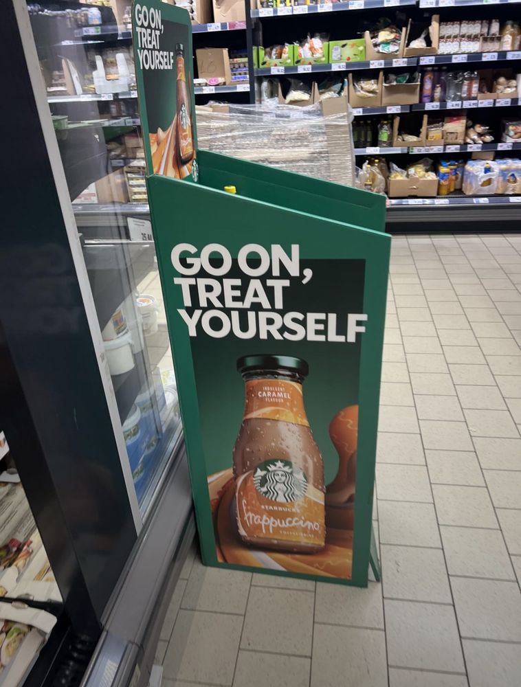 A Starbucks Frappuccino display in a grocery store. Do to catastrophic kerning it reads:

GOON,
TREAT YOURSELF 