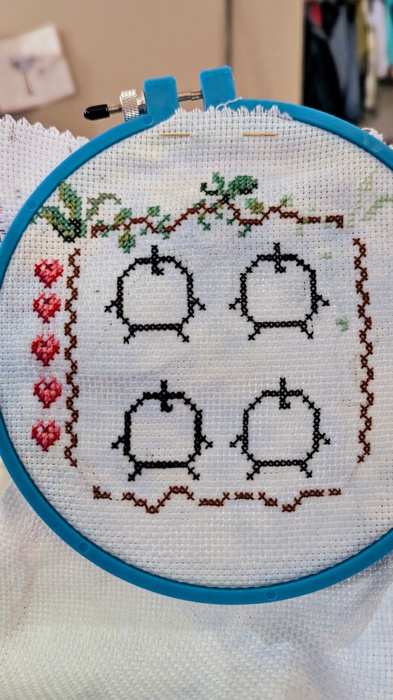 A half-complete cross stitch pattern of junimos from the game, Stardew Valley.