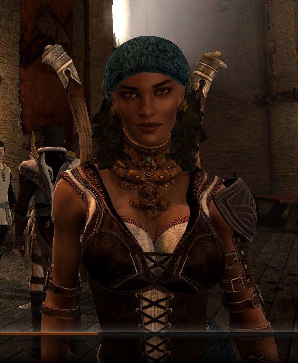 Cropped screenshot from dragon age 2 showing a modded Isabela. who is a woman with brown skin, she has a wider nose and fuller lips than her vanilla counterpart. she has on dark brown lipstick and smoky black eye make-up, golden brown eyes, dark hair in tight curls, held back by a blue bandana. she has a gold lip piercing under her bottom lip in the middle as well as large gold earrings.

she is wearing a golden necklace that covers the entirety of her neck and has circular pieces that go down her chest. her clothing consists of a dark brown leather corset laced in the front, with a white shirt underneath with a red decorative trim. she is wearing leather straps on her arms and on her left she is wearing a leather shoulder spaulder.

she has two daggers affixed to her back