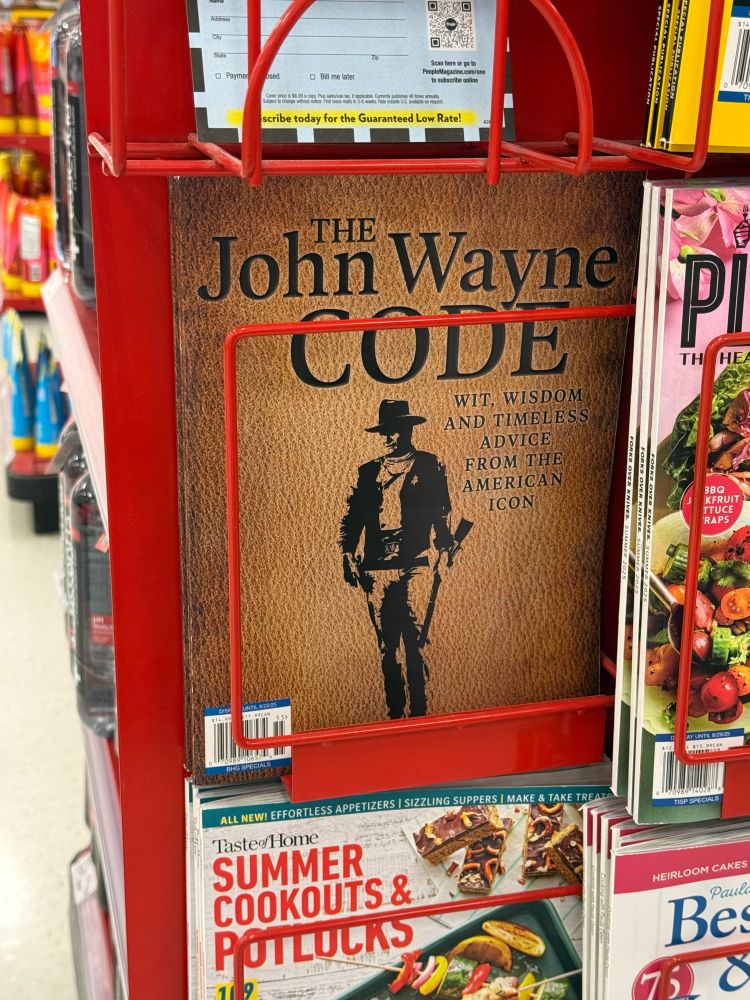Grocery store magazine stand with a magazine titled The John Wayne Code.