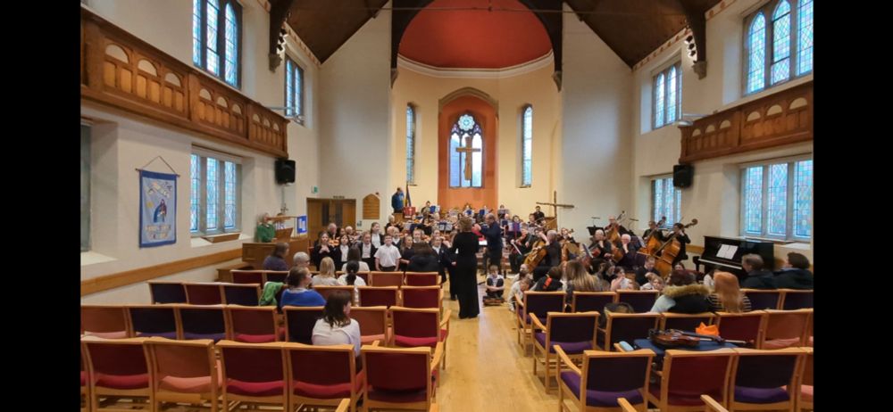 An orchestra and a choir of children singing John Sturt's music on its premiere