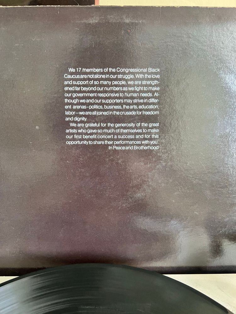 The back cover of the same album, featuring a message from the Congressional Black Caucus. The text acknowledges the collective fight for justice and thanks the artists for their contributions to a benefit concert. The record is partially visible at the bottom of the frame.
