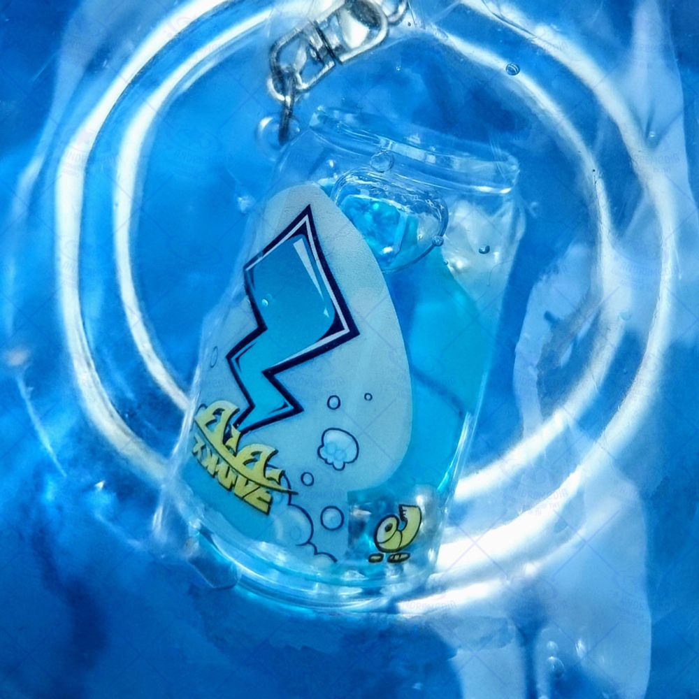 A picture of my merchandise - a transparent, liquid-filled keychain that resembles a Tacticooler from Splatoon 3 - floating in a clear bowl of blue water