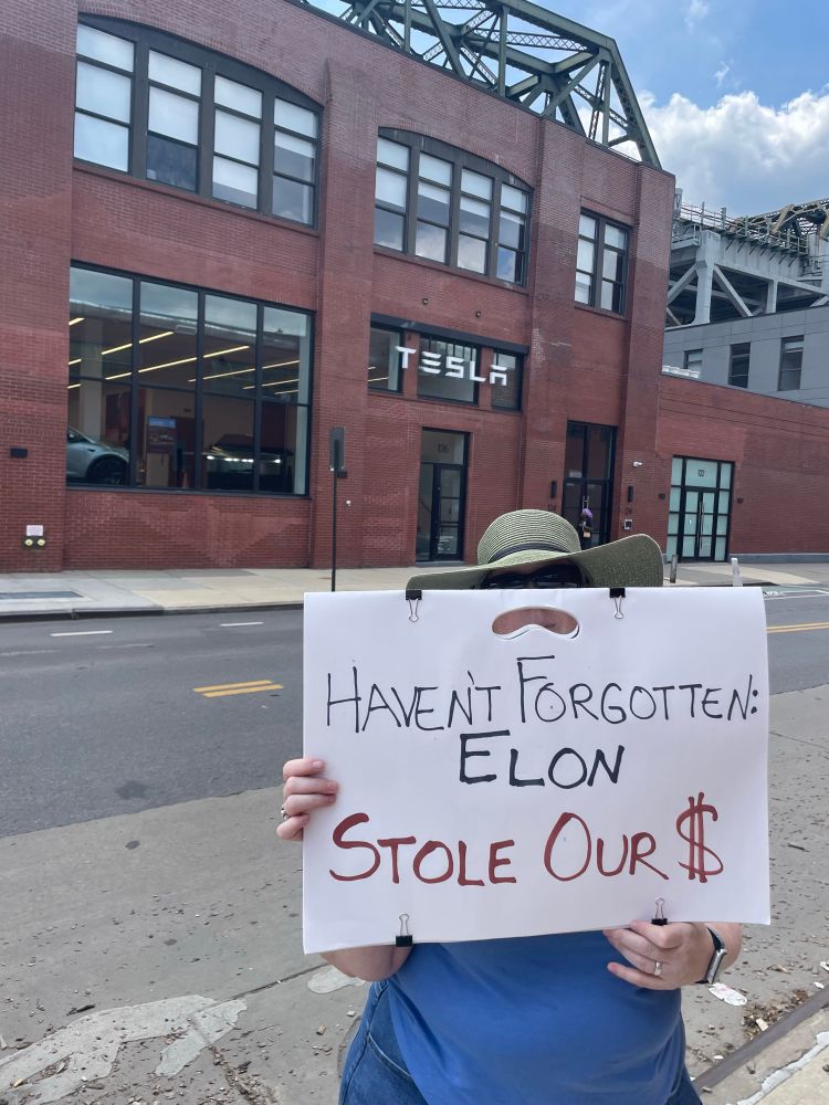 TeslaTakedown sign says “Haven’t forgotten: Elon stole our money”