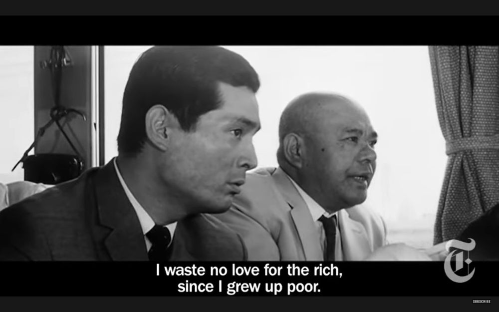 The slightly older man, Chief Detective Taguchi, turns to look ahead at the same man, responding, "I waste no love for the rich, since I grew up poor."