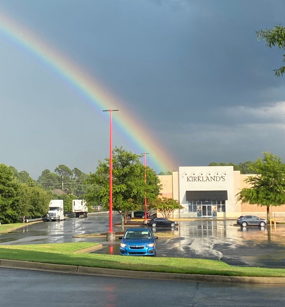 a big fresh rainbow in the sky, above a kirklands store.