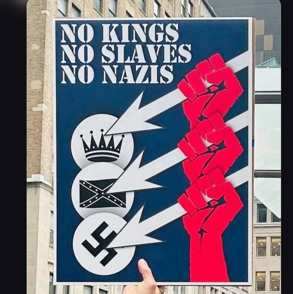 Na poster hanging up that says no Kings no slaves no Nazis with three red hands, pointing to a crown a confederate flag and a swastika