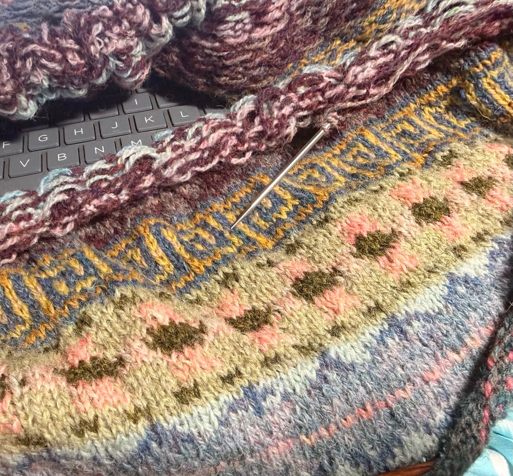 Fair isle sweater in primarily pastels colors including blue, purple, green, and pink. 