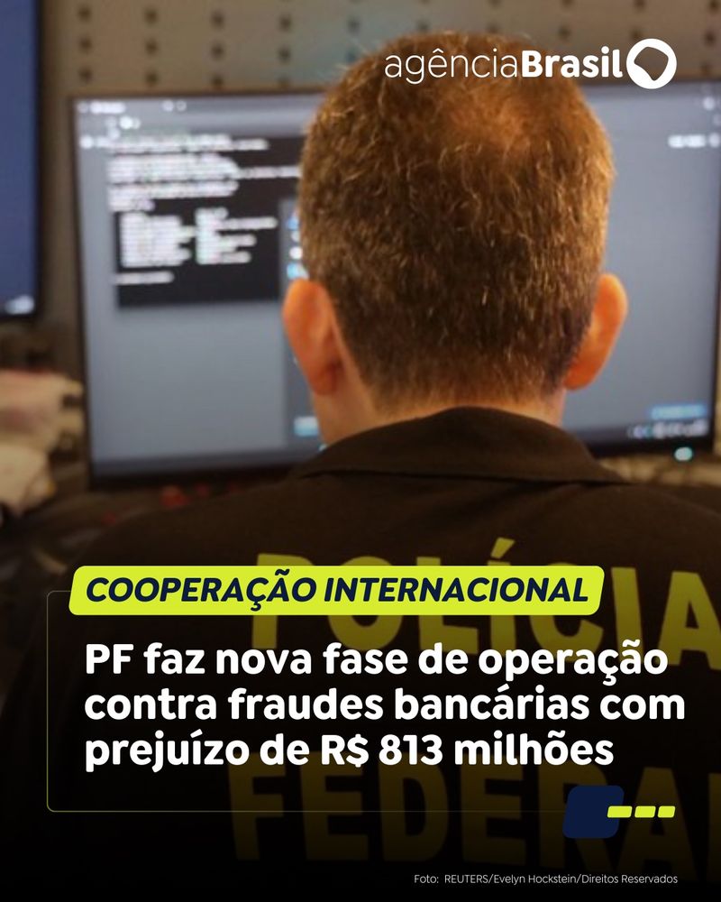 Fotografia mostra agente da PF, de costa, mexendo em computador. Ele está de costas, trajando camisa preta onde está escrito POLÍCIA FEDERAL em letras amarelas. Na parte inferior, está escrito: “COOPERAÇÃO INTERNACIONAL - PF faz nova fase de operação contra fraudes bancárias com prejuízo de R$ 813 milhões".