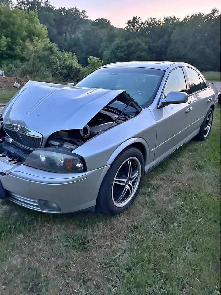 2003 lincoln ls, silver, really fucked up in the front, bonnet wedges inward, probably due to a front end collision