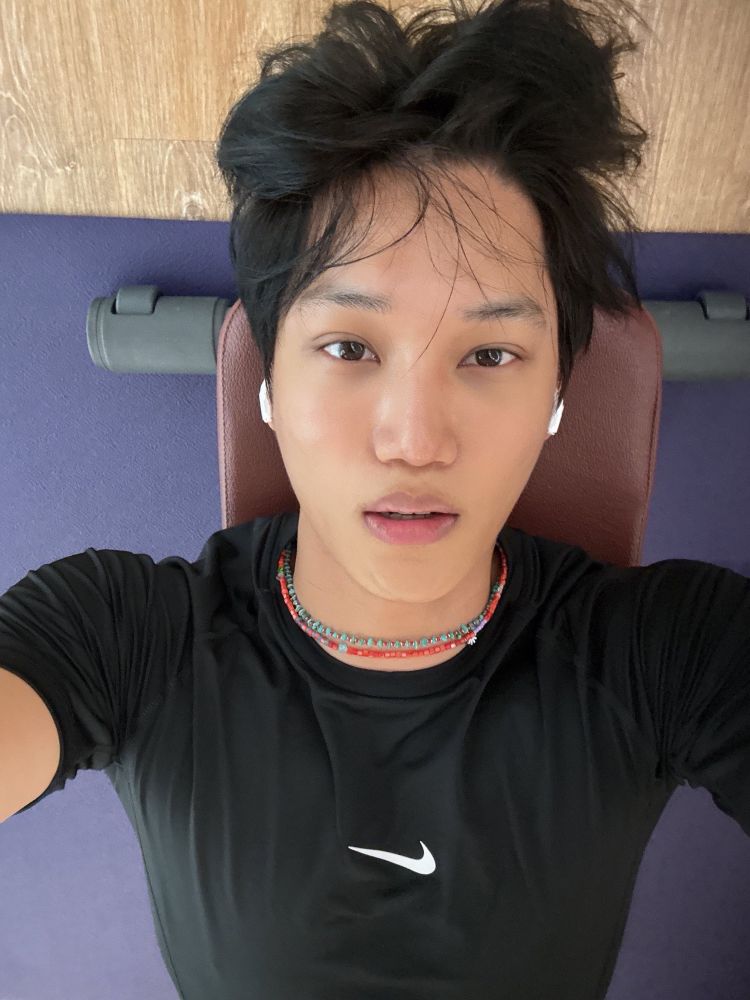 Kai from EXO laying on a workout bench, looking FINE fine.