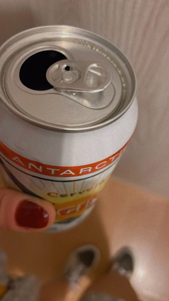 Lata de Cerveja original segurada por uma mão feminina.