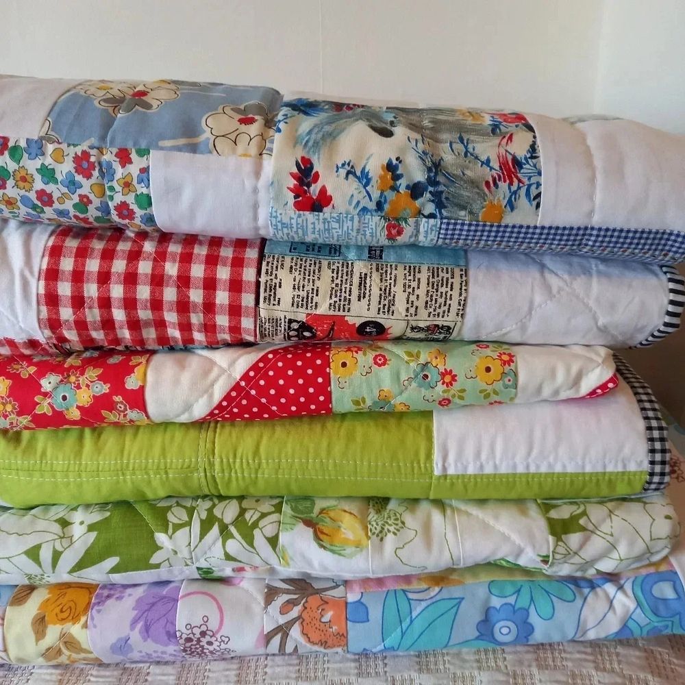 A pile of colourful patchwork quilts.