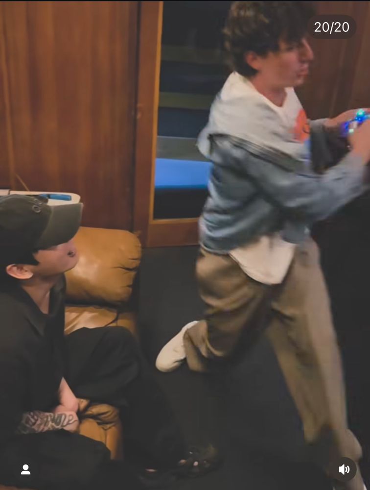 Charlie Puth playing with a shiny toy in front of BTS Jung Kook