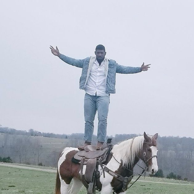 Ed Oliver standing on a horse