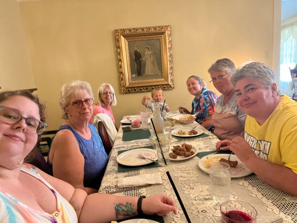Six women and a toddler boy sit around a rectangular table with a lace tablecloth. They are already full from the “relish” (appetizer) course, but the main course was still to come. It was all delicious.