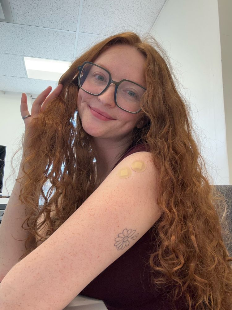 selfie of Keely, showing two band-aids on upper arm from getting vaccines