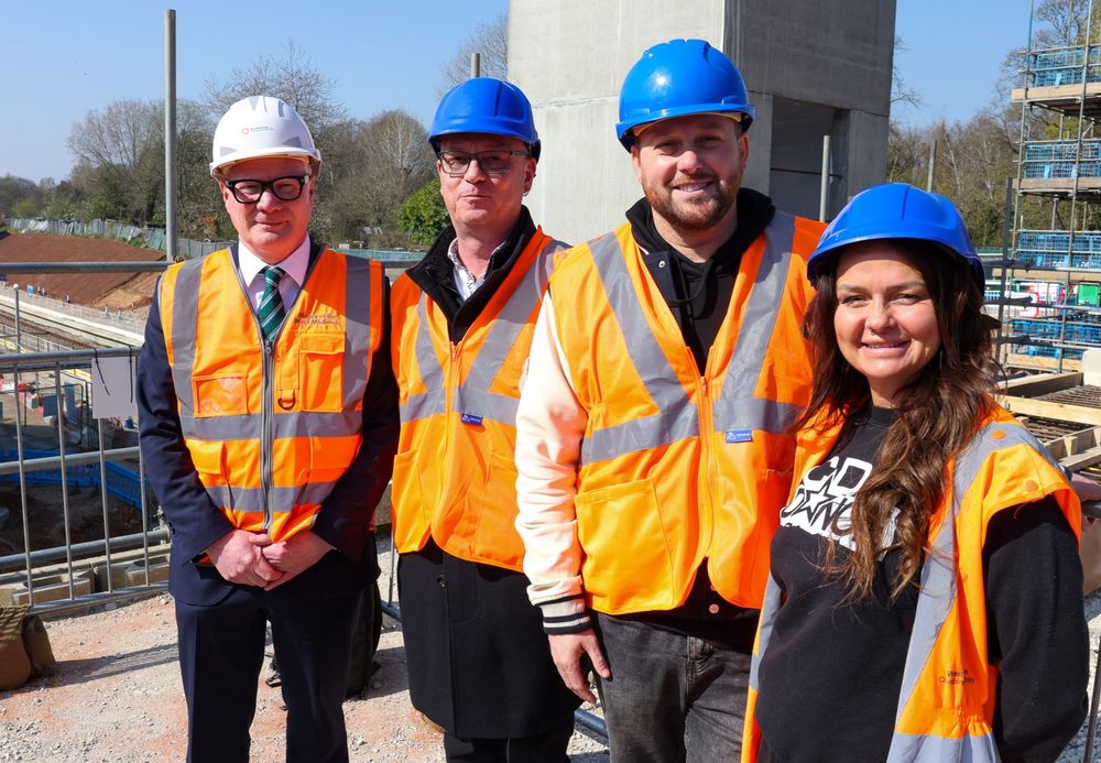 Four people standing at a construction site.
