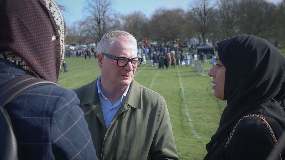 Three people engaging in a conversation at a park.