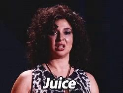 a woman with curly hair is wearing a black and white dress and necklace and says juice .