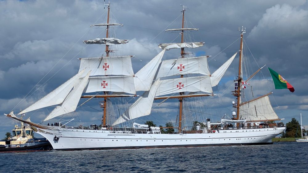 Segelschiff mit wenigen gehissten Segeln unter portugiesischer Flagge.