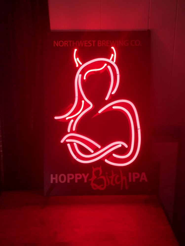Neon sign in red glowing neon. Below it reads hoppy bitch IPA