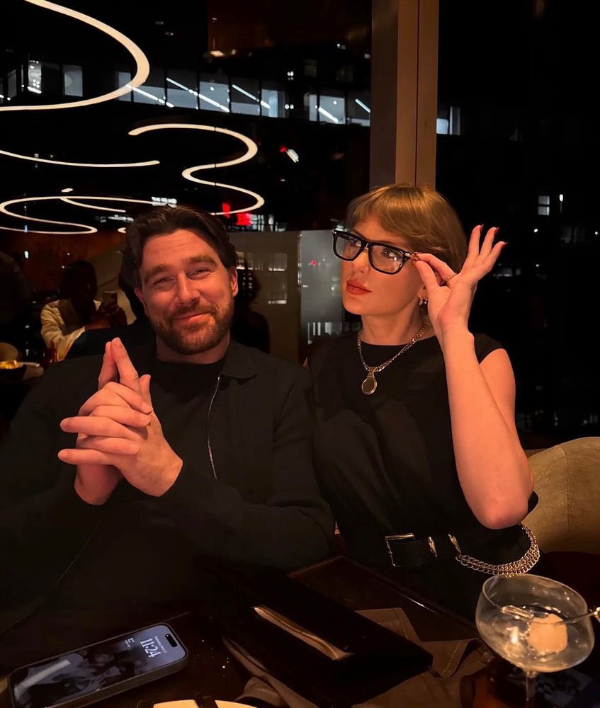 Taylor swift and tracks is at dinner, she’s playing with his glasses 