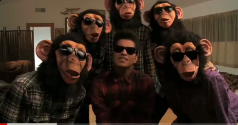 a group of people wearing monkey masks and sunglasses pose for a picture