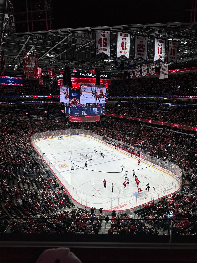 Wide shot of Capital one arena with Capitals vs. Kings being played on the ice 