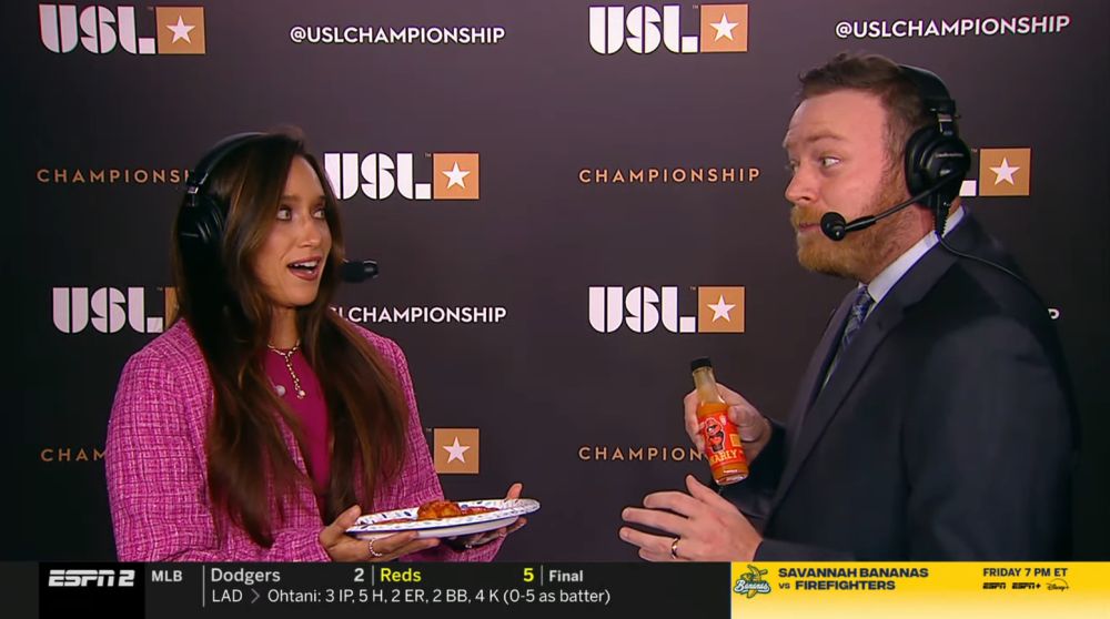 Marion Crowder and Mike Watts with Mike holding a bottle of hot sauce
