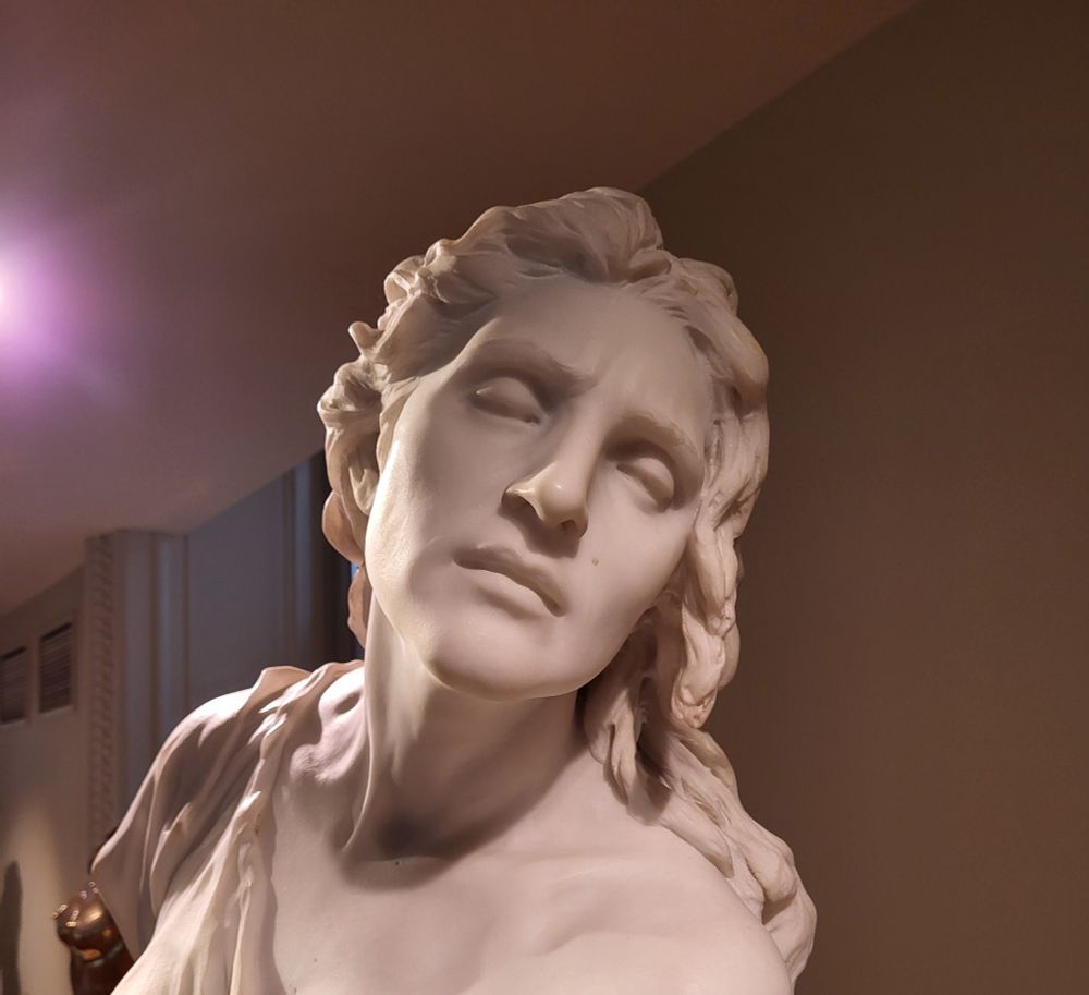 Marble statue of a woman who is clearly exhausted 