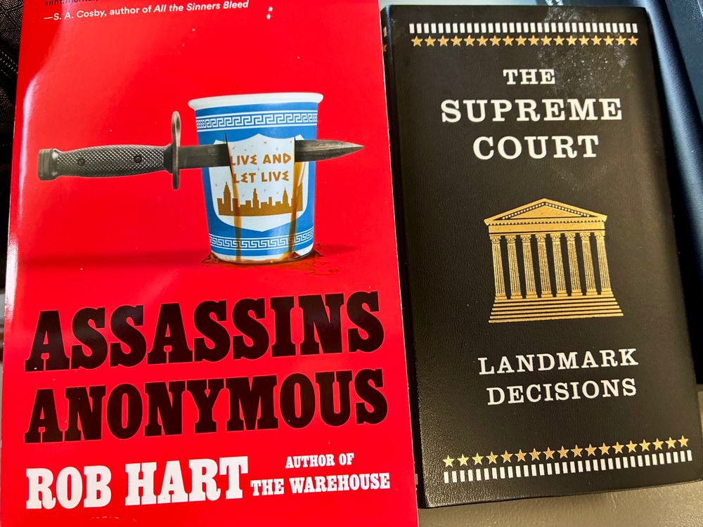 Books I’m reading now. Assassins Anonymous by Rob Hart and Supreme Court Landmark Decisions. 