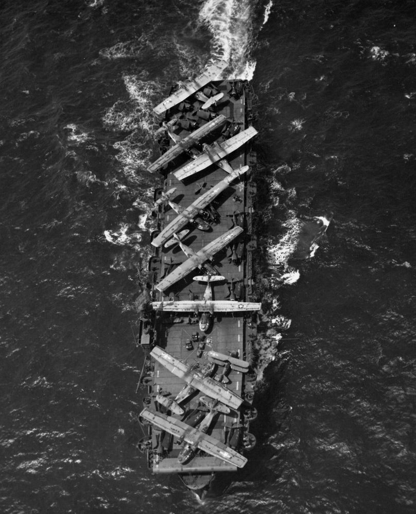 Thetis Bay ferrying inoperable aircraft to NAS Alameda, 8 July 1944. Visible onboard are eight PBY Catalina flying boats, eighteen F6F Hellcat fighters, and a J2F Duck amphibious biplane.