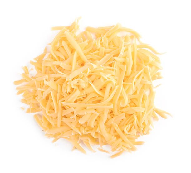 a pile of shredded cheddar cheese against a plain backdrop