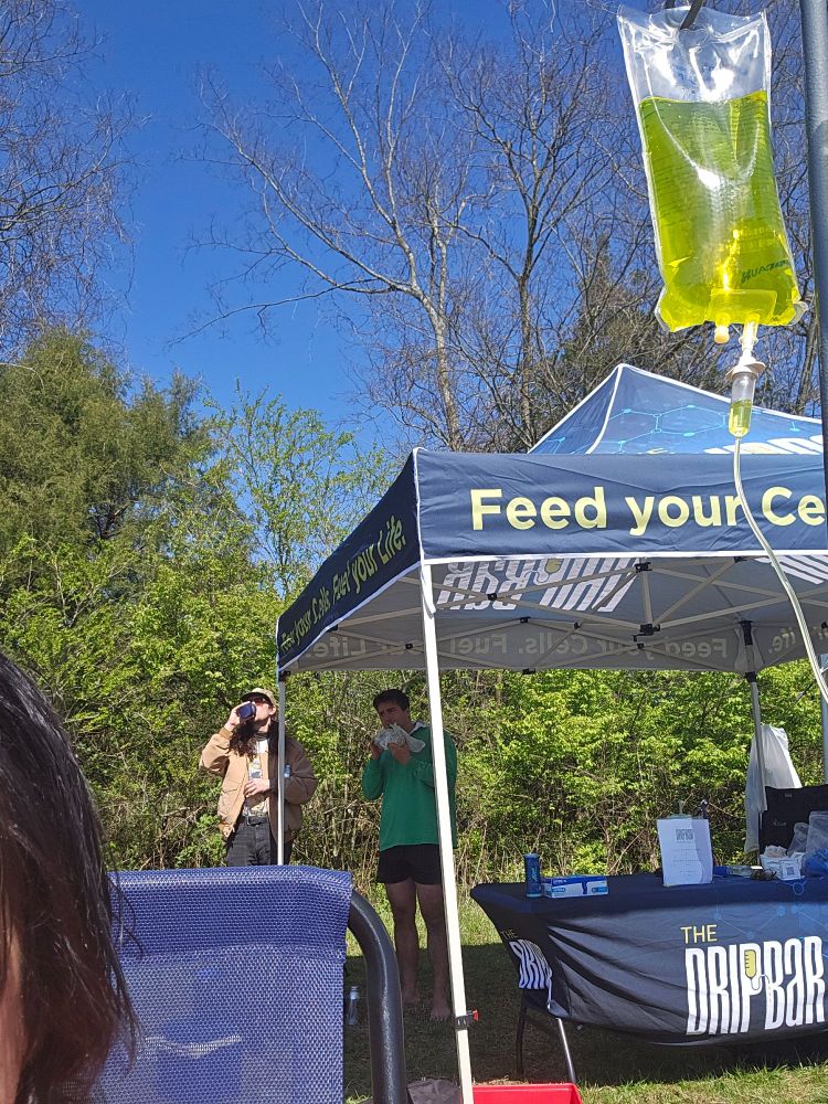 A picture of a yellow iv fluid bag in front of a portable tent