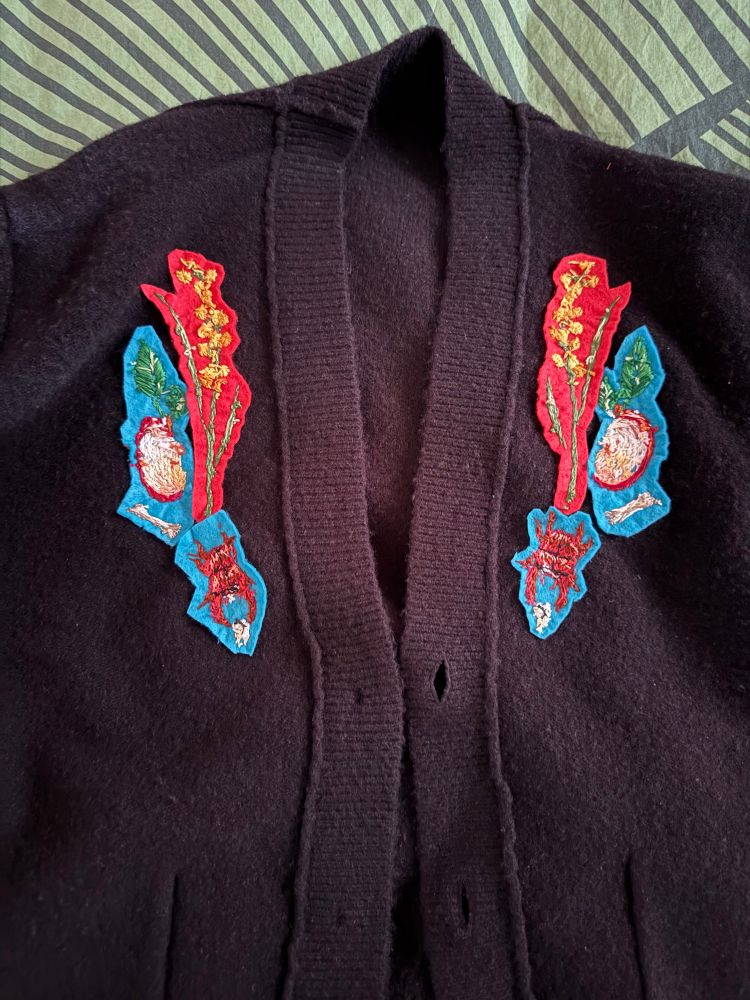 Inside the cardigan, showing the backside of the embroidery, which has been backed with pieces of felt 