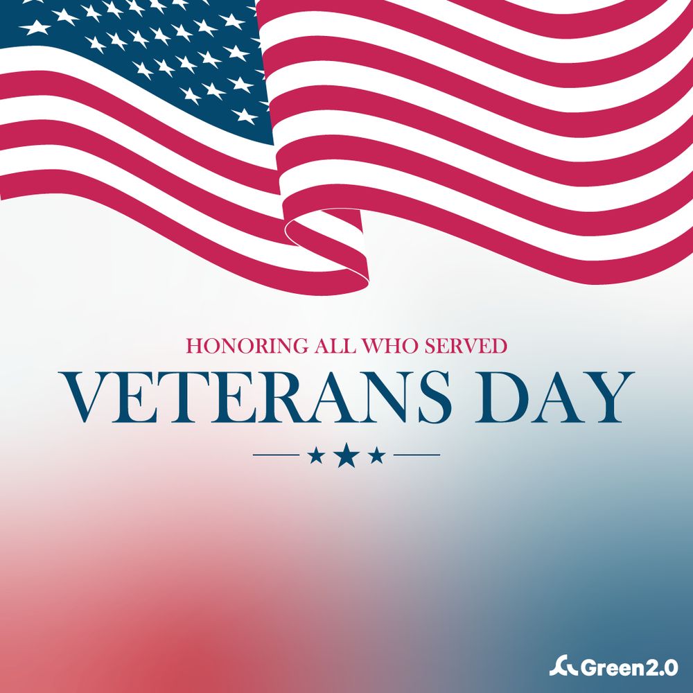 Graphic featuring a large stylized American flag waving across the top. Below it, text reads: ‘Honoring All Who Served — Veterans Day,’ with three stars beneath. The background fades from white to red and blue. Green 2.0 logo appears in the bottom right corner.