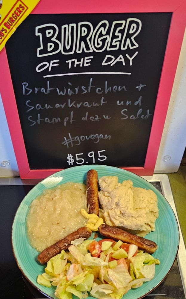 Bob's Burger Tafel mit
Bratwürstchen +
Sauerkraut und
Stampf dazu Salat
#govegan
$5.95
Darunter Teller mit den Speisen, geformt wie das Friedenssymbol.
