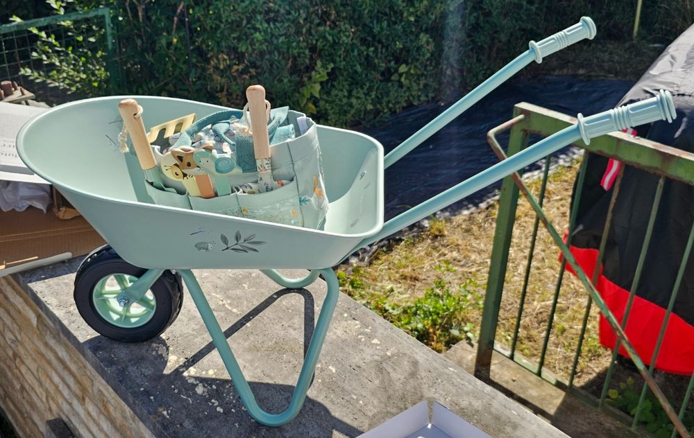 Zusammengebaute Schubkarre mit Tasche und Gartenwerkzeug.