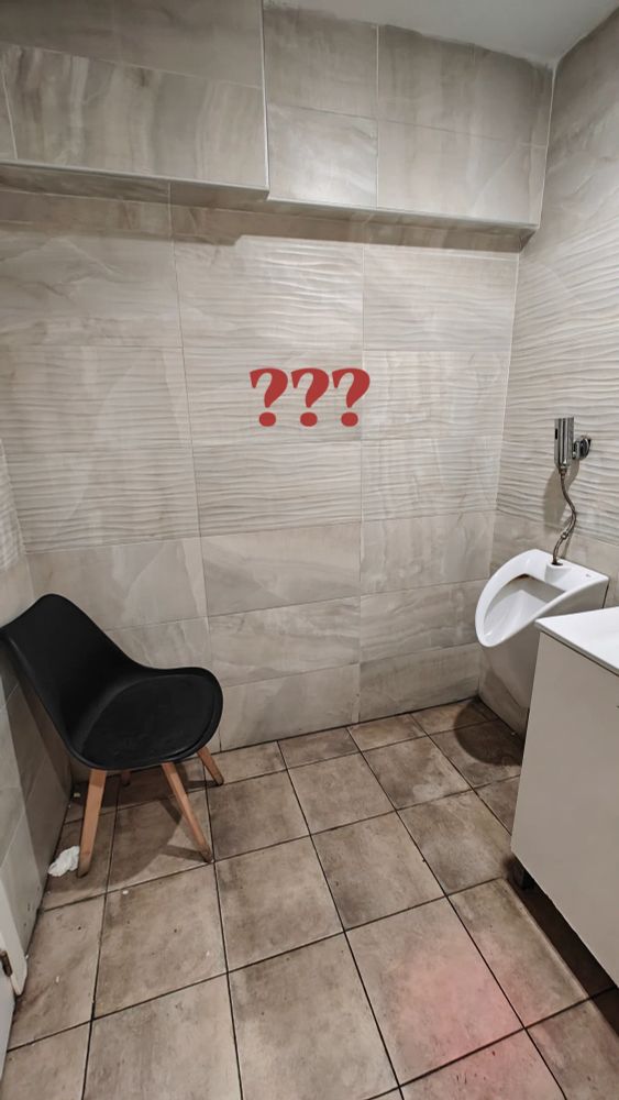 a chair in front of a standing toilet 