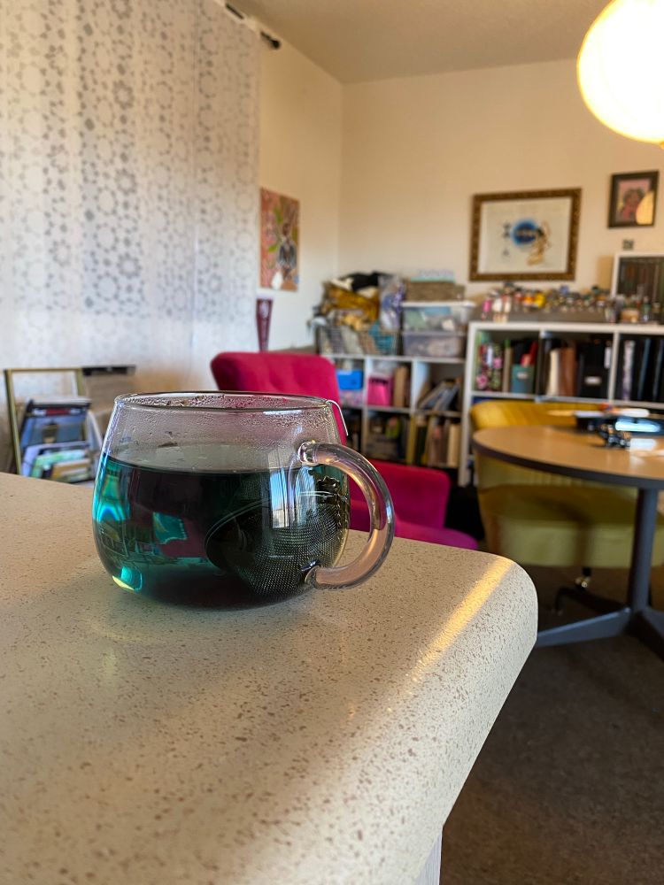 Glass teacup with emerald green tea
