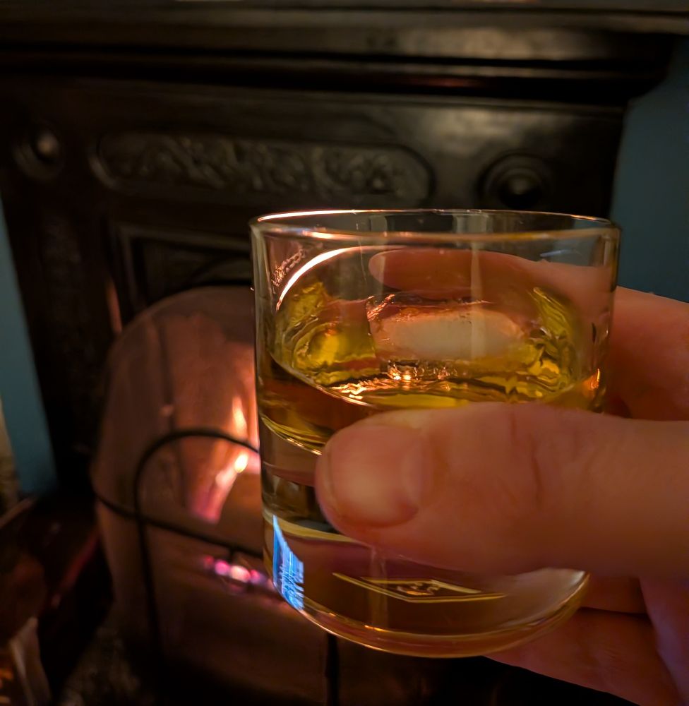 Glad of whiskey in front of a fire. 