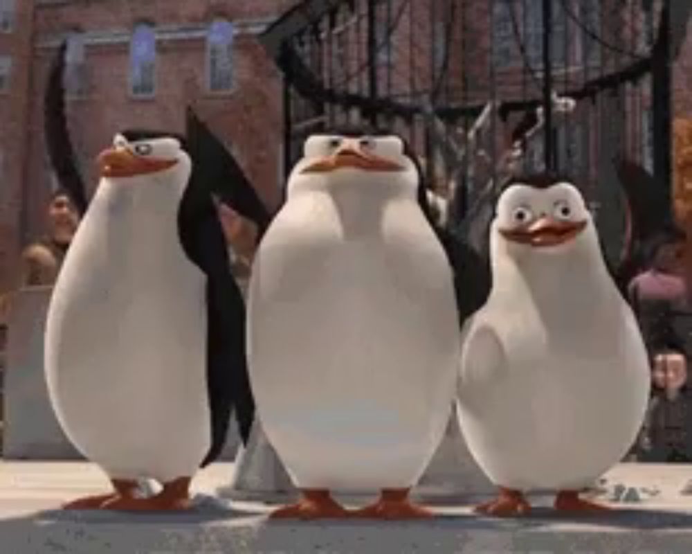 three penguins from madagascar are standing next to each other and looking at the camera .