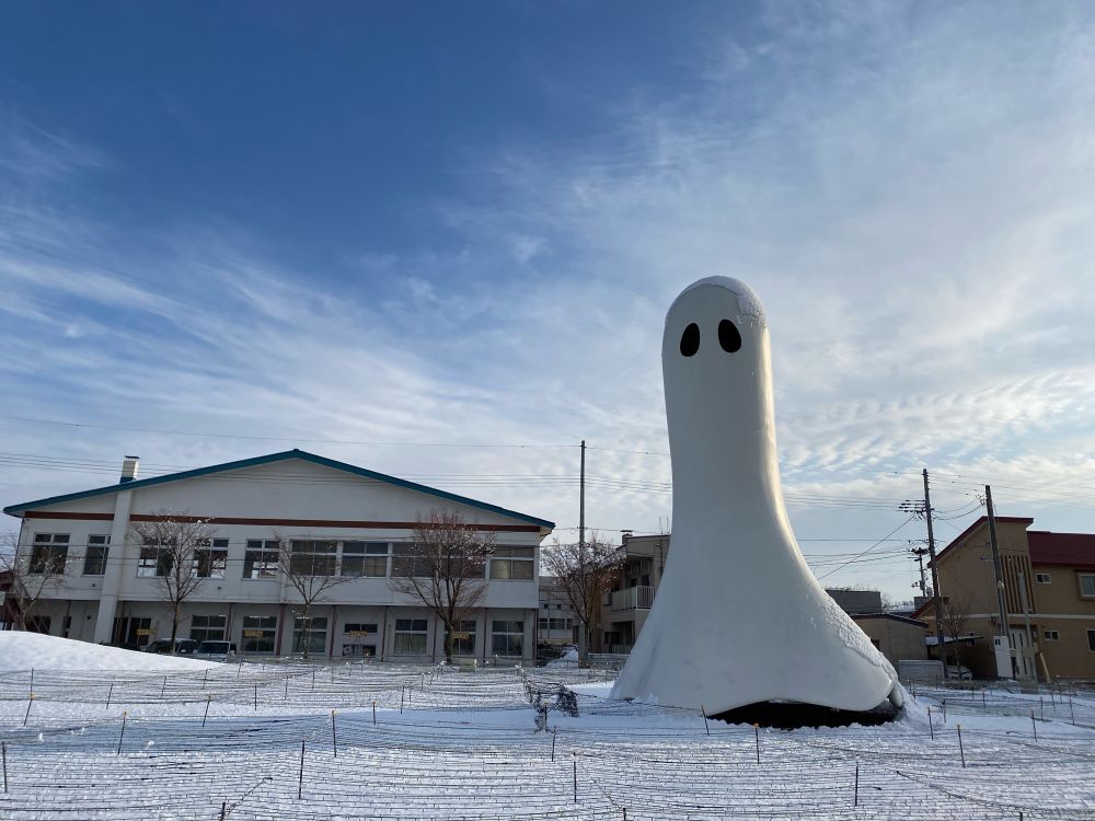 十和田市現代美術館の野外展示。雪の中に、白いおばけのような巨大なオブジェがある。