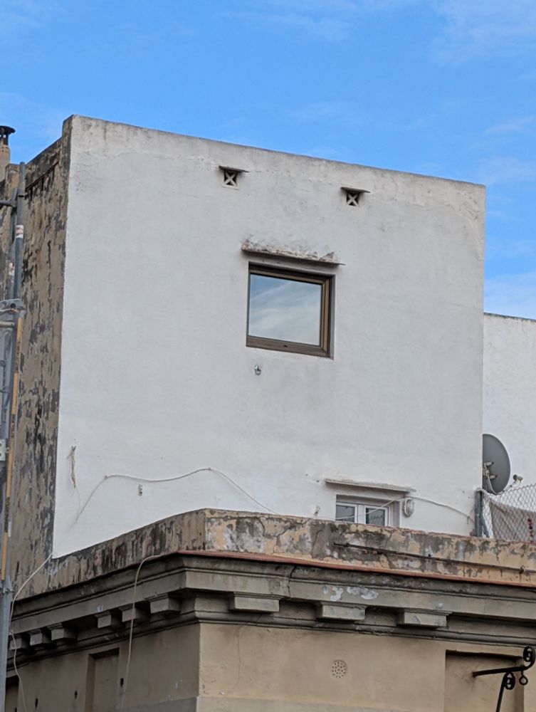 Un bloque construido en la azotea de un edificio en el cual la ventana y dos rendijas misteriosas justo encima (desagües?) forman lo que parece una cara gritando de espanto.