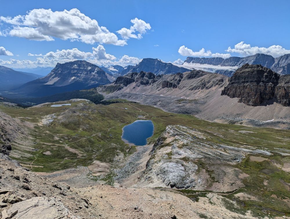 a mountain view with a small blue lake