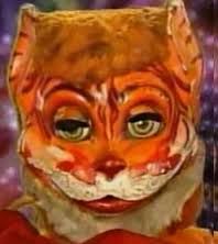 Picture showing a strange cat ventriloquism puppet with bizarre smeared painting, giant smile, and uneven inhuman-like eyes as featured by artist David Liebe Hart in a segment 