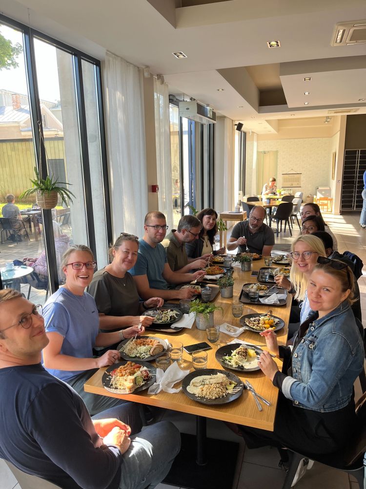 Tartu Microbiome team members and Prof. Tove Fall's group members sitting around a table and having lunch together. 