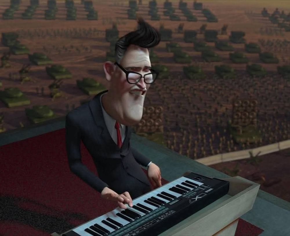 A man in a suit and glasses furiously plays a synthesizer 